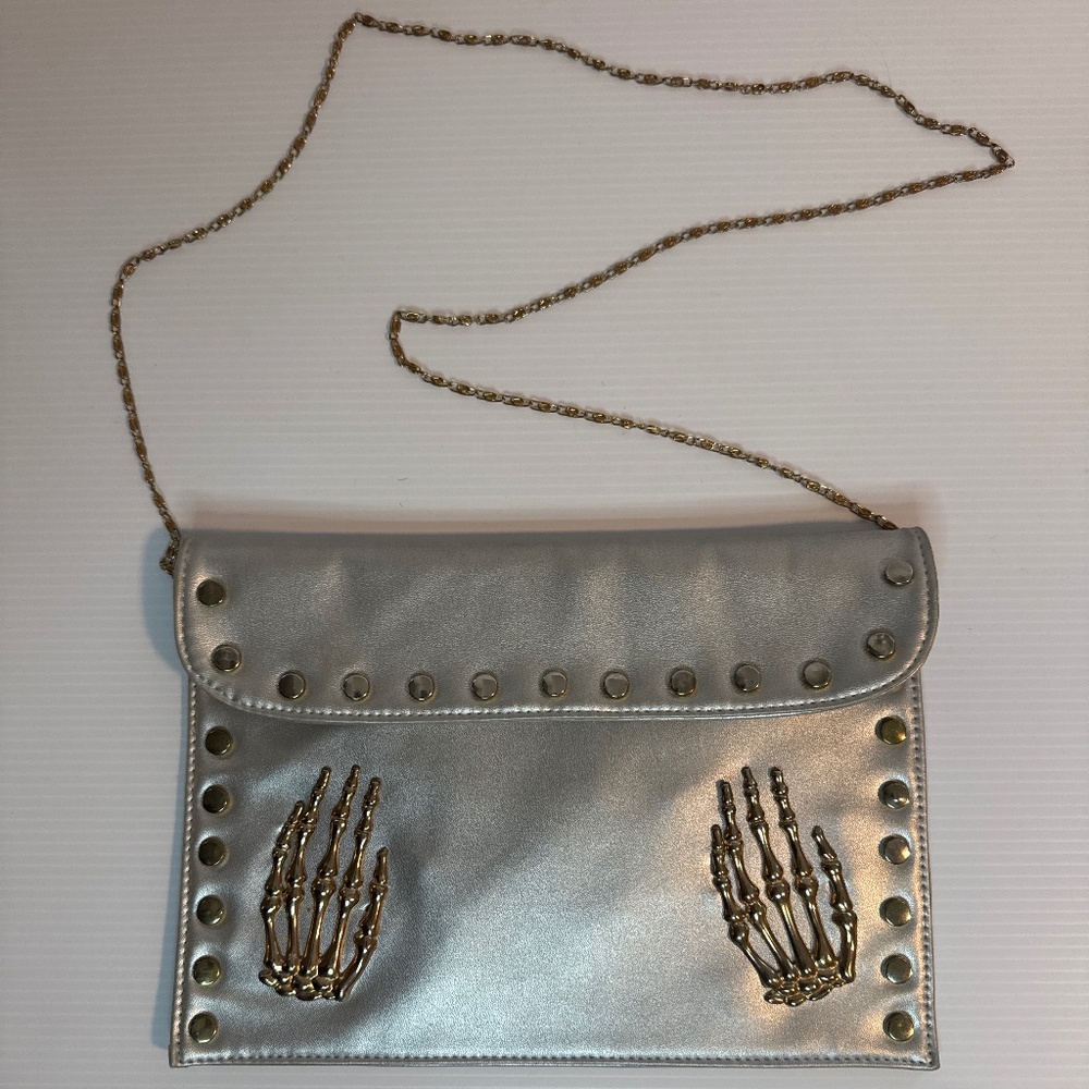 Skeleton hand clutch bag with metal accents